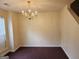 A dining room with neutral walls, carpet flooring, and a brass chandelier at 2337 Carousel Park Dr, Morrow, GA 30260