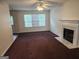 A living room with carpet flooring, a fireplace with marble surround, and bright windows at 2337 Carousel Park Dr, Morrow, GA 30260