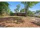 A red brick home featuring a large backyard with mature trees and partially cleared area at 264 Rockin Hill Sw Dr, Marietta, GA 30060