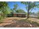 A red brick home featuring a large backyard with mature trees and a covered patio at 264 Rockin Hill Sw Dr, Marietta, GA 30060