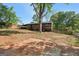 A red brick home featuring a large backyard with mature trees, a covered patio and partially cleared area at 264 Rockin Hill Sw Dr, Marietta, GA 30060
