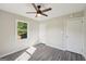 A bright bedroom with gray wood-look flooring, a ceiling fan and natural light from the large window at 264 Rockin Hill Sw Dr, Marietta, GA 30060
