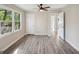 A bright bedroom with gray wood-look flooring, a ceiling fan and natural light from the large window at 264 Rockin Hill Sw Dr, Marietta, GA 30060