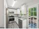 Bright kitchen has white cabinetry, stainless appliances, and a door to the back deck at 264 Rockin Hill Sw Dr, Marietta, GA 30060