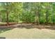 Wooded backyard area featuring a volleyball net, wood storage, and chairs at 270 Polk Rd, Covington, GA 30014