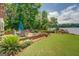 Landscaped backyard features a stone patio, manicured lawn, and views of the lake at 270 Polk Rd, Covington, GA 30014