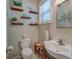 Charming powder room featuring decorative shelves, toilet, and a stylish vessel sink at 270 Polk Rd, Covington, GA 30014