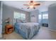 Light blue bedroom featuring a patterned comforter set, white dresser, and bright natural light at 270 Polk Rd, Covington, GA 30014