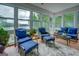 Bright sunroom featuring views of the lake and trees, and wicker furniture with blue cushions at 270 Polk Rd, Covington, GA 30014