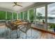 Sunroom featuring a dining table with view of the lake, windows on three sides, and a ceiling fan at 270 Polk Rd, Covington, GA 30014