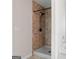 The bathroom features a walk-in shower with black hardware and natural stone look wall panels at 11755 Lovejoy Crossing Blvd, Hampton, GA 30228