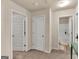 Well-lit hallway featuring neutral paint, carpeting and access to rooms with white doors at 11755 Lovejoy Crossing Blvd, Hampton, GA 30228