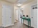 Bright hallway with multiple doorways and a cute table with flowers, leading to various rooms at 11755 Lovejoy Crossing Blvd, Hampton, GA 30228