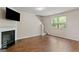 Bright living room featuring a fireplace, hardwood floors, and large windows at 11755 Lovejoy Crossing Blvd, Hampton, GA 30228
