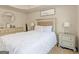 This primary bedroom features a plush white comforter, large windows, and elegant silver dressers at 11755 Lovejoy Crossing Blvd, Hampton, GA 30228