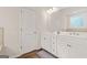 Bright bathroom features a double vanity with white cabinetry and modern fixtures, paired with wood-look flooring at 790 Riverwood Pass, Dallas, GA 30157