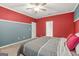 Comfortable bedroom with red and blue walls, carpet flooring and ceiling fan at 790 Riverwood Pass, Dallas, GA 30157