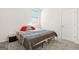 Cozy bedroom featuring neutral carpeting and minimal décor, highlighted by vibrant red pillows and soft natural light at 790 Riverwood Pass, Dallas, GA 30157
