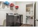 Laundry room with stainless steel washer and dryer, plus overhead shelving at 790 Riverwood Pass, Dallas, GA 30157