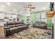 Open-concept living room showcasing two leather sofas, fireplace, and modern ceiling fan at 790 Riverwood Pass, Dallas, GA 30157