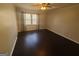 A cozy bedroom with dark wood floors, a ceiling fan, and a bright window to let in light at 222 Flat Creek Ct, Peachtree City, GA 30269