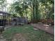 A large backyard area with a deck, fire pit, and animal enclosure in a serene, wooded setting at 1253 Heartwood Ave, Mcdonough, GA 30253
