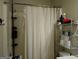 The bathroom features a shower with a curtain, shelving for storage, and toiletries at 1253 Heartwood Ave, Mcdonough, GA 30253
