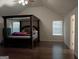 A bedroom with high ceilings, wood floors and a large, four-poster bed, creating a Primary suite at 1253 Heartwood Ave, Mcdonough, GA 30253