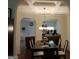 Dining room with dark table and white chairs, decorative lighting, and arched doorways at 1253 Heartwood Ave, Mcdonough, GA 30253