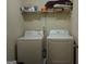 The laundry room has a washer and dryer with a shelf above for storage at 1253 Heartwood Ave, Mcdonough, GA 30253