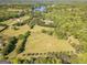 Aerial view of a lush, green landscape with scattered homes and a serene lake in the background at 13819 Woolsey Rd, Hampton, GA 30228