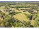 Expansive aerial view of the property showcasing lush green fields, mature trees, and surrounding neighborhood at 13819 Woolsey Rd, Hampton, GA 30228