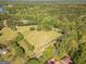 Expansive aerial view of a property featuring lush green fields, mature trees, and scattered buildings at 13819 Woolsey Rd, Hampton, GA 30228