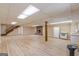 Unfinished basement with vinyl plank flooring, brick fireplace, utility kitchen and stairwell access to upper levels at 13819 Woolsey Rd, Hampton, GA 30228