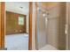 Modern bathroom with a glass-door shower and a connecting bedroom with paneled walls and a window with ample light at 13819 Woolsey Rd, Hampton, GA 30228