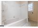 Bathroom features a tile tub, shower combination, and a bright window at 13819 Woolsey Rd, Hampton, GA 30228