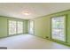 Bright bedroom with green trim features three large windows offering abundant natural light at 13819 Woolsey Rd, Hampton, GA 30228