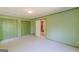 Green bedroom with closet and door to another room; features neutral carpet and white ceiling at 13819 Woolsey Rd, Hampton, GA 30228