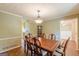 Cozy dining room with wood floors and adjacent kitchen, with a chandelier and a wooden table at 13819 Woolsey Rd, Hampton, GA 30228