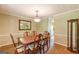 Classic dining room with wood floors, wainscoting, chandelier, and large wood dining table at 13819 Woolsey Rd, Hampton, GA 30228