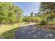 Scenic driveway surrounded by mature trees and wooden fencing leading to a beautiful property at 13819 Woolsey Rd, Hampton, GA 30228