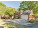 Home exterior with brick and siding, featuring an attached garage and a spacious driveway at 13819 Woolsey Rd, Hampton, GA 30228