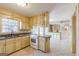 Open kitchen with tile floors, light wood cabinets, modern appliances, and ample counter space at 13819 Woolsey Rd, Hampton, GA 30228