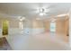 Large living room with carpet flooring, three ceiling fans, and wainscoting at 13819 Woolsey Rd, Hampton, GA 30228