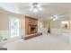 An open living room features a brick fireplace, two ceiling fans, and lots of light at 13819 Woolsey Rd, Hampton, GA 30228