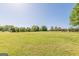 Expansive green field featuring various trees and a shelter with a red roof in the background at 13819 Woolsey Rd, Hampton, GA 30228