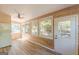 Bright sunroom with wood paneling, a ceiling fan, lots of windows and a laundry area at 13819 Woolsey Rd, Hampton, GA 30228