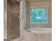 Elegant bathroom showcasing a soaking tub, glass-enclosed shower, and marble-like tiling at 1162 Ida Woods Ln # 23, Lawrenceville, GA 30045