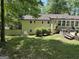 Exterior view of the home featuring a backyard with a well-maintained lawn and a deck with a hot tub at 15 Perthshire Dr, Peachtree City, GA 30269