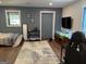 Bedroom with hardwood floors, a large area rug, stylish decor, a TV, and access to the outdoors at 15 Perthshire Dr, Peachtree City, GA 30269
